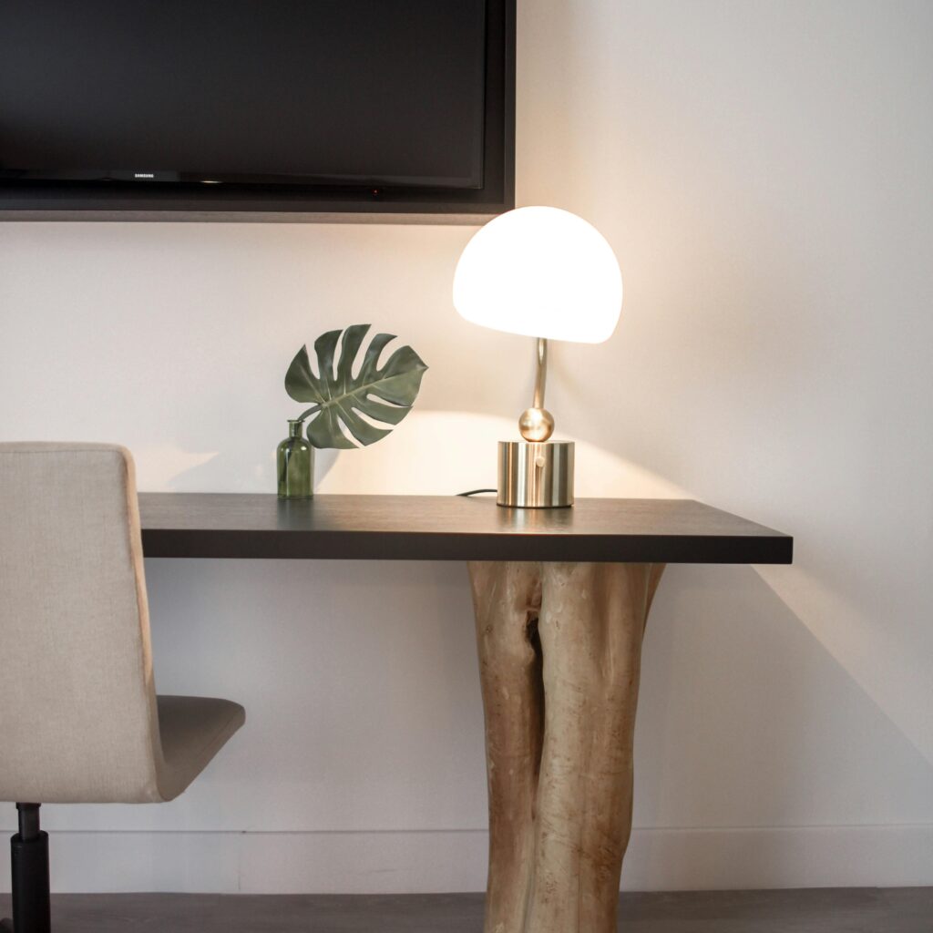 Elegantly designed modern workspace featuring a unique wood table, chair, and lamp.